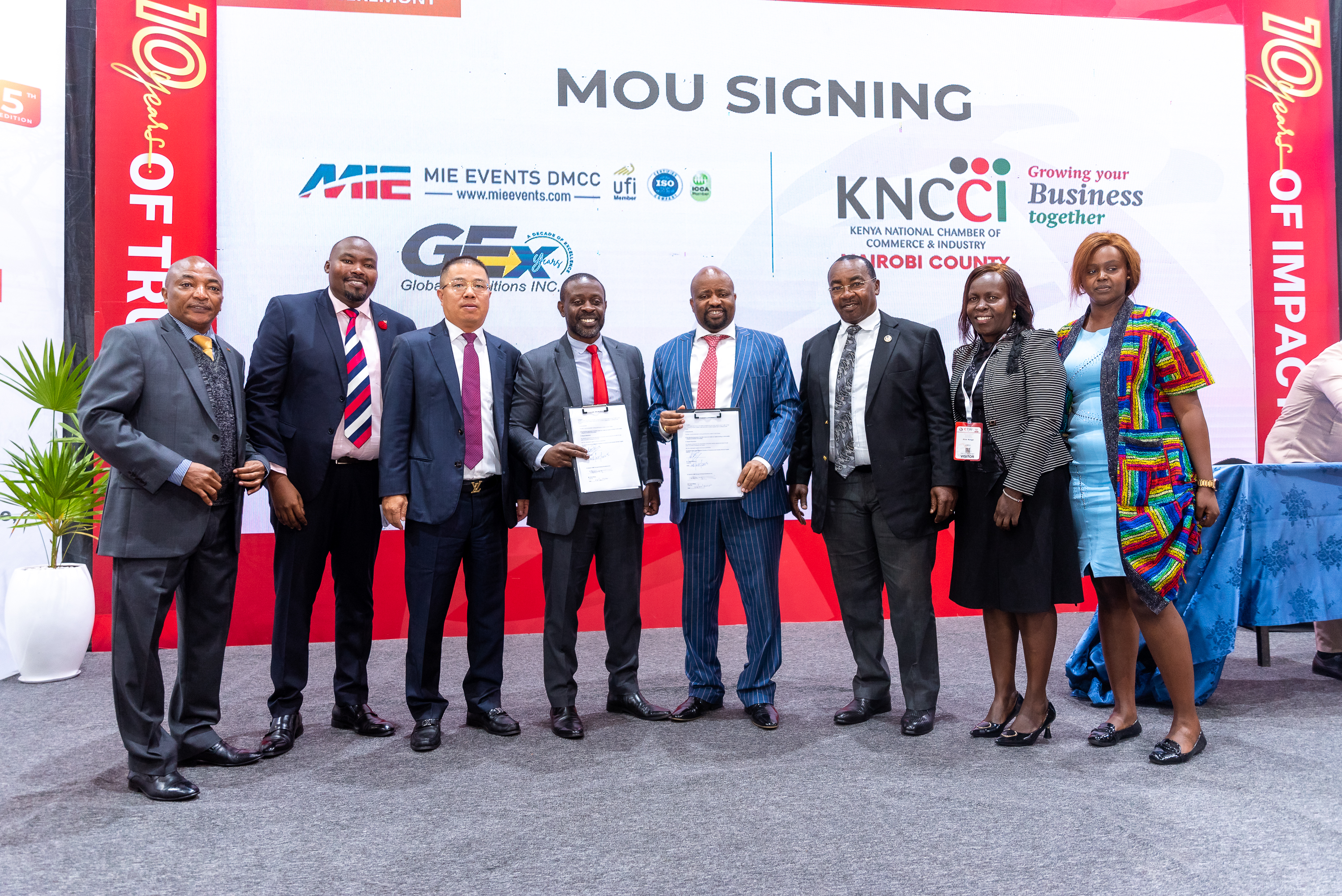 Guests holding signed documents at the MoU signing