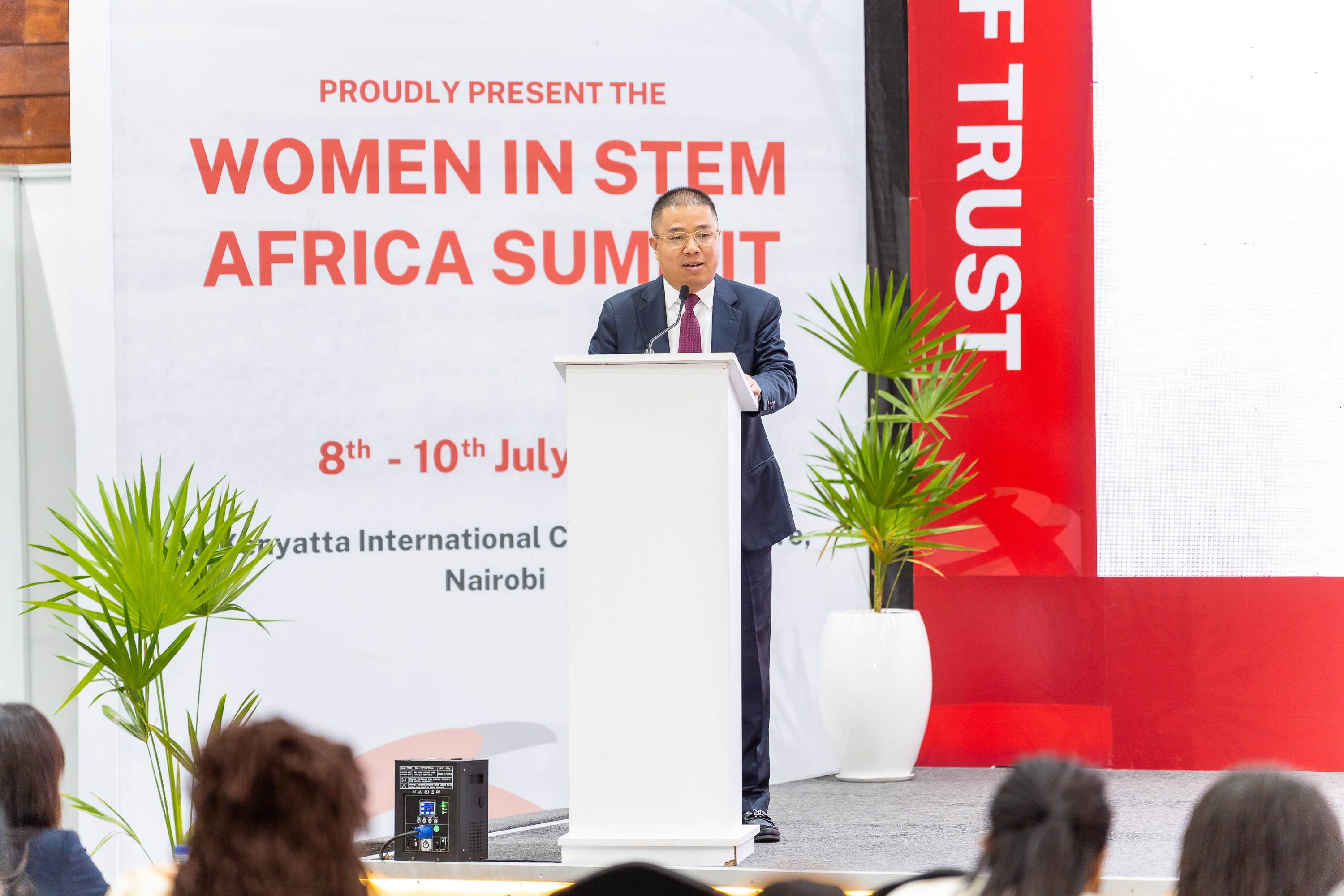 A speaker at the podium in front of the Women in STEM Africa Summit banner