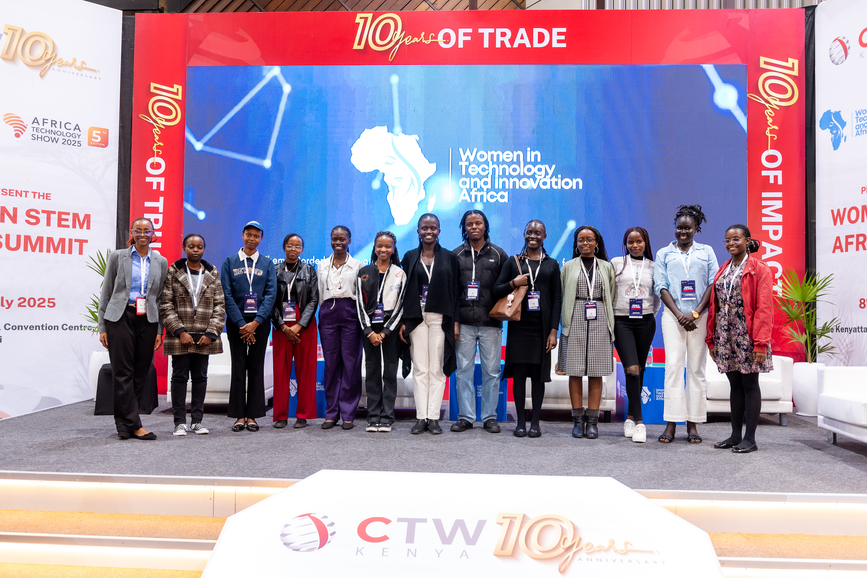 A large group of attendees on stage in front of the WITIA screen