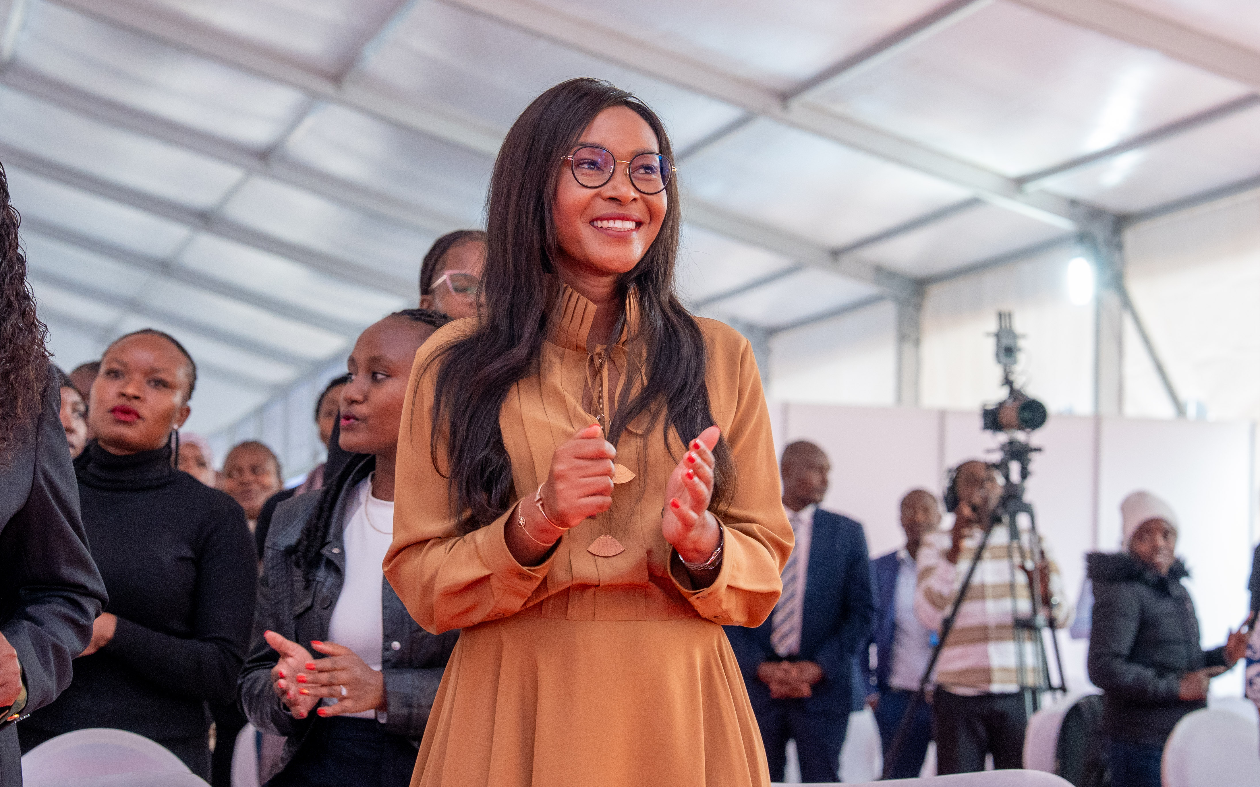 An attendee smiling and clapping in the audience