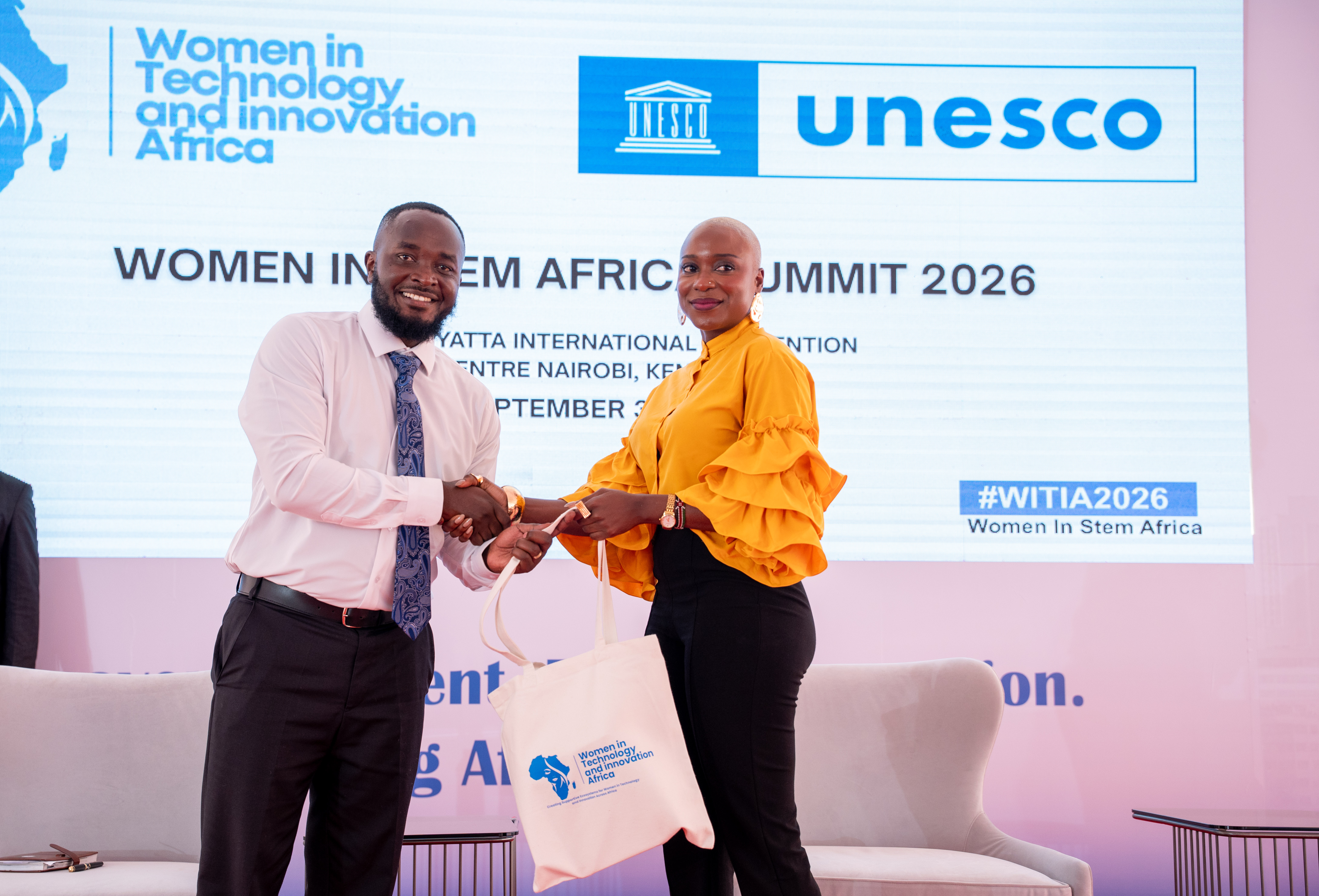 A speaker receiving a gift bag on stage